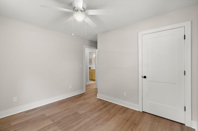 unfurnished bedroom featuring light wood finished floors, baseboards, and a ceiling fan