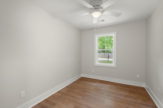 spare room with wood finished floors, baseboards, and ceiling fan