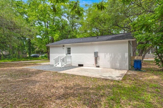 back of house with brick siding and a patio