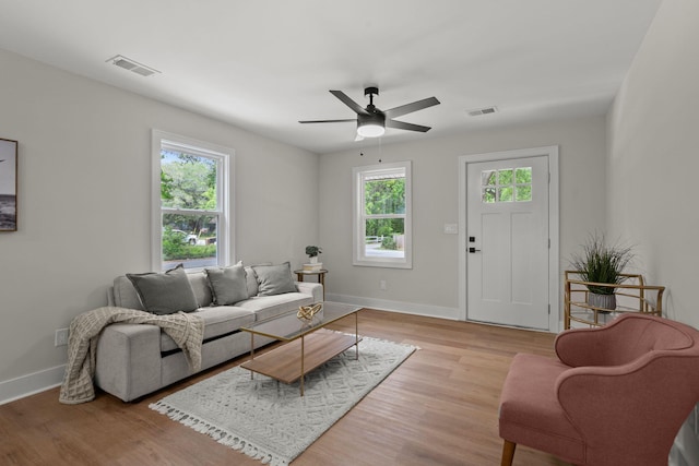 living room with healthy amount of natural light, baseboards, light wood-style flooring, and ceiling fan