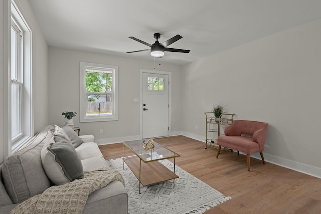 living room with baseboards, ceiling fan, and wood finished floors