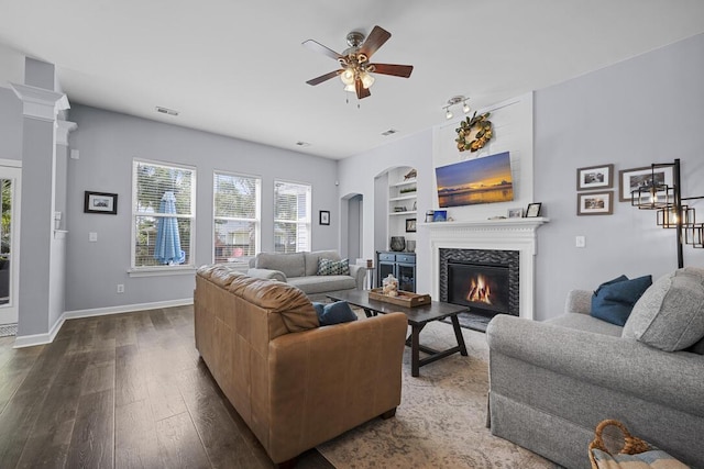 185 Red Leaf Blvd, Moncks Corner, SC 29461 - living area with a ceiling fan, dark wood finished floors, built in features, a glass covered fireplace, and arched walkways