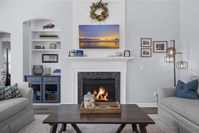185 Red Leaf Blvd, Moncks Corner, SC 29461 - living room with arched walkways, wood finished floors, a warm lit fireplace, built in features, and baseboards