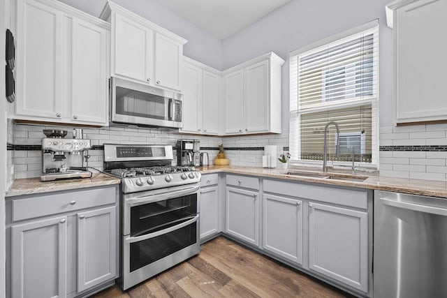 185 Red Leaf Blvd, Moncks Corner, SC 29461 - kitchen with stainless steel appliances, a sink, decorative backsplash, dark wood finished floors, and light stone counters