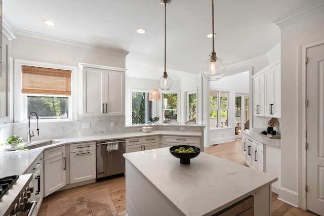 kitchen with light countertops, a center island, a sink, backsplash, and dishwasher
