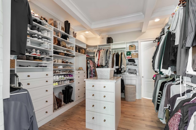spacious closet featuring beamed ceiling, light wood-style floors, and coffered ceiling