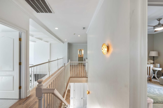 corridor featuring ornamental molding, an upstairs landing, visible vents, and wood finished floors