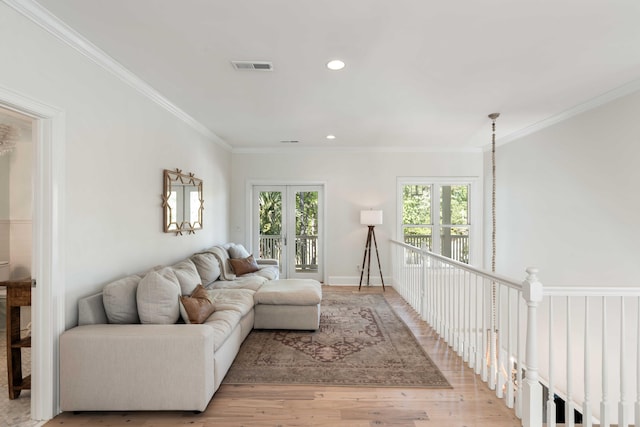 living room featuring ornamental molding, visible vents, light wood-style flooring, and recessed lighting