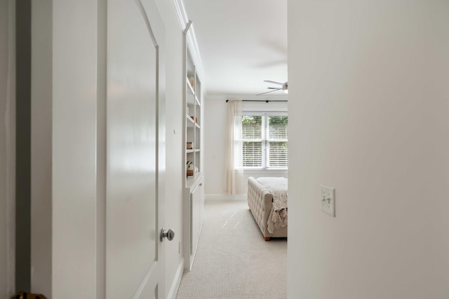 corridor with baseboards and light carpet