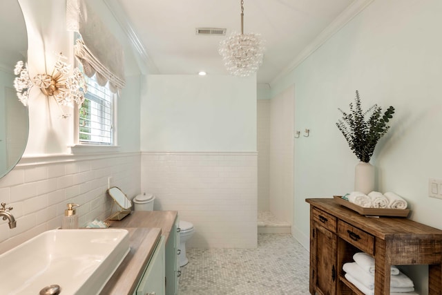 bathroom with toilet, a notable chandelier, walk in shower, vanity, and ornamental molding