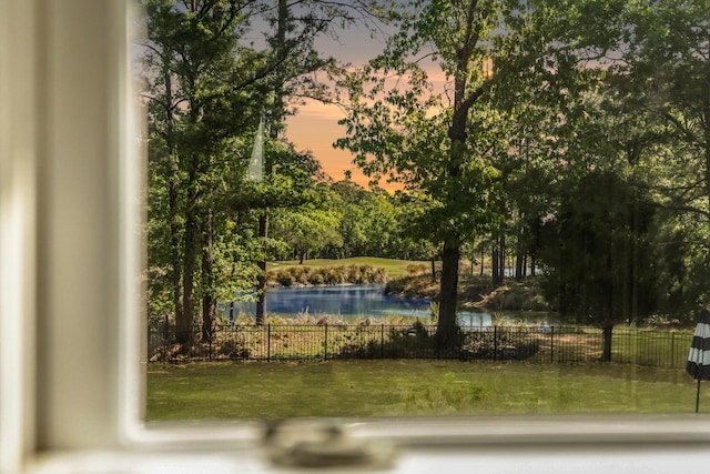 exterior space featuring fence and a water view