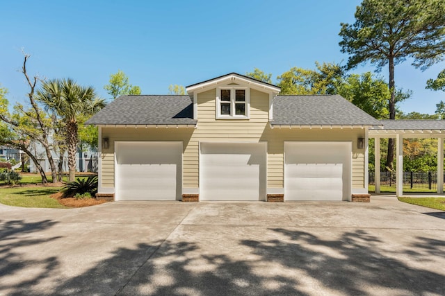 view of front of home with roof with shingles, fence, a garage, and driveway