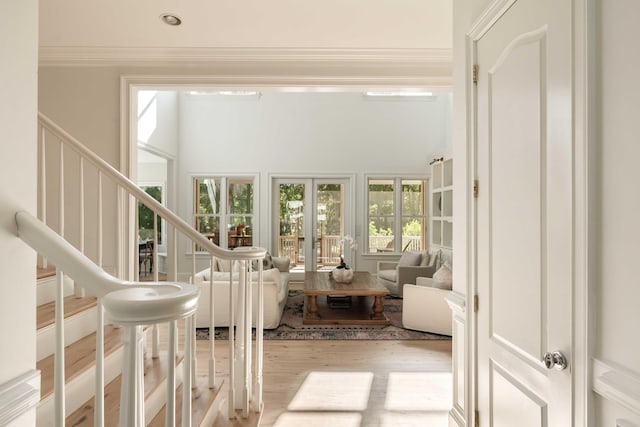 interior space with ornamental molding, stairway, and wood finished floors