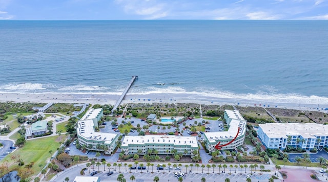 birds eye view of property with a water view and a beach view