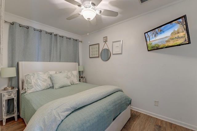 bedroom featuring baseboards, visible vents, ceiling fan, wood finished floors, and crown molding