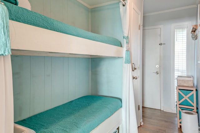 bedroom featuring ornamental molding and wood finished floors