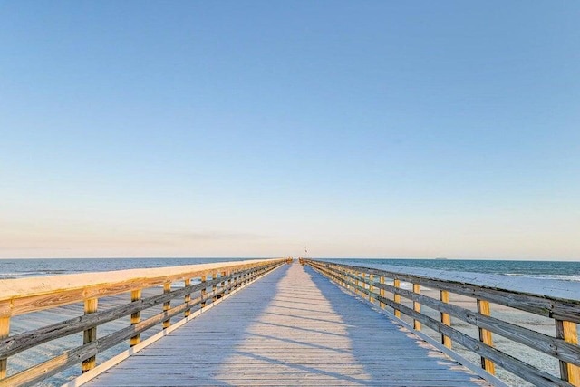 view of dock featuring a water view and a view of the beach