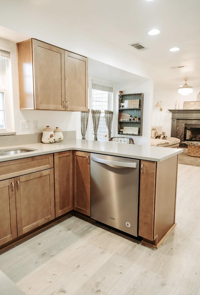 kitchen with light wood-type flooring, open floor plan, light countertops, and dishwasher