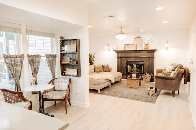 sitting room with visible vents, wood finished floors, a high end fireplace, and recessed lighting