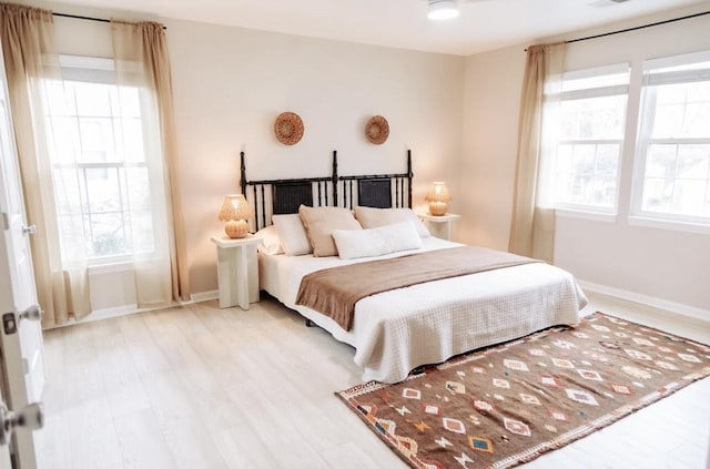 bedroom with light wood-style floors and baseboards