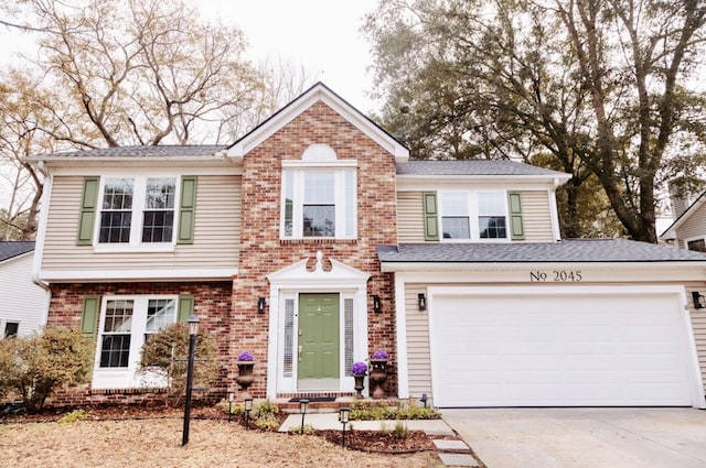 traditional home with a garage, concrete driveway, and brick siding