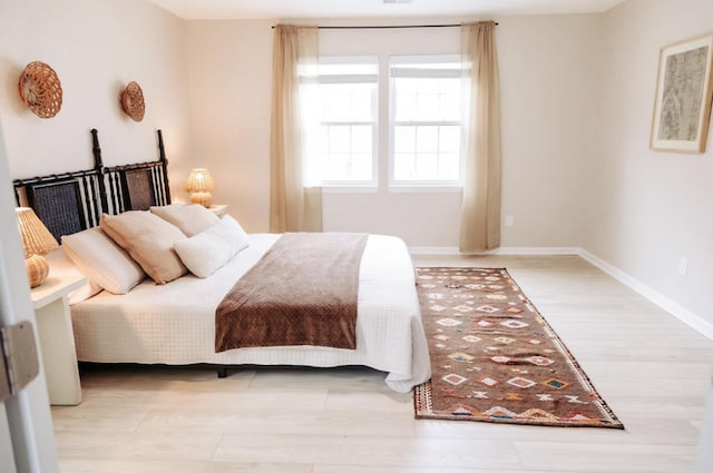 bedroom with light wood-style floors and baseboards