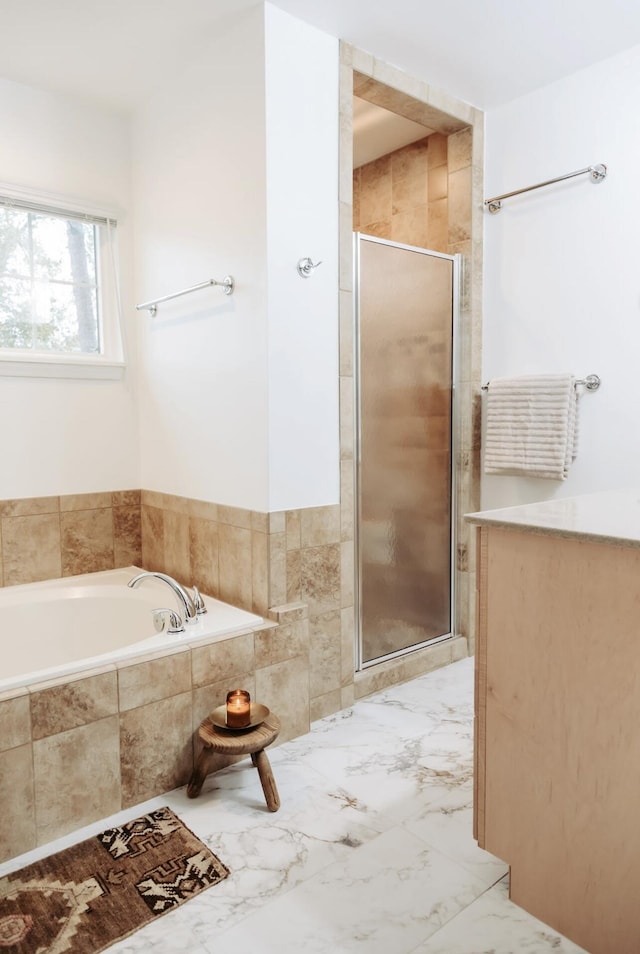 full bathroom with a stall shower, marble finish floor, and a garden tub