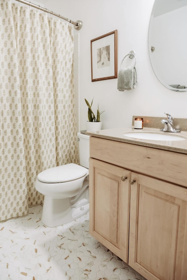 full bath with toilet, vanity, and tile patterned floors