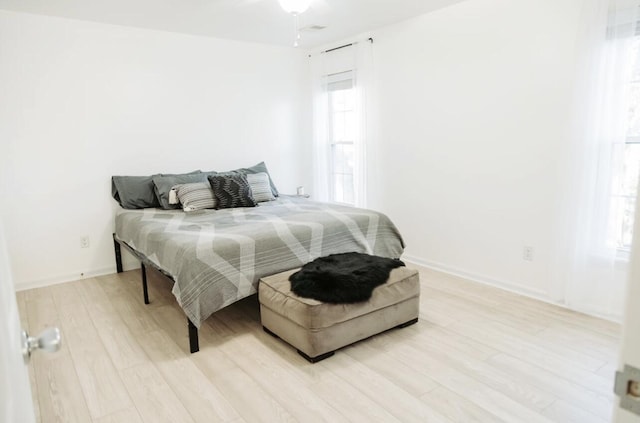 bedroom with light wood-style flooring and baseboards