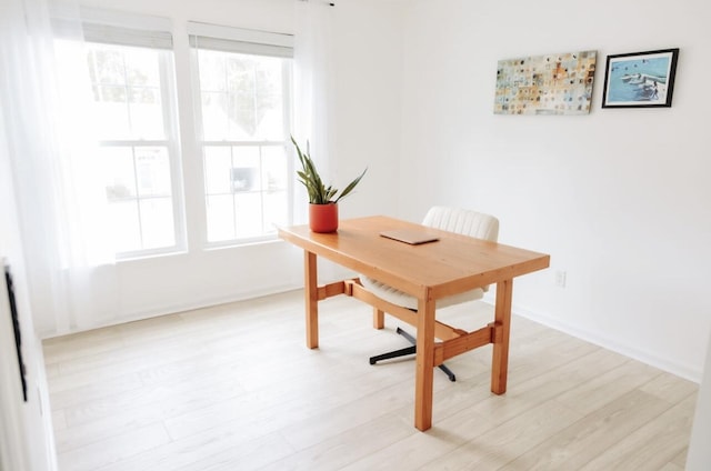 home office featuring light wood-type flooring, baseboards, and a wealth of natural light