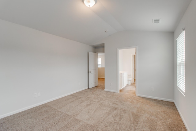 1816 Casein St, Summerville, SC 29483 - unfurnished bedroom with visible vents, lofted ceiling, baseboards, ensuite bathroom, and light colored carpet