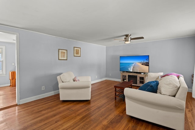 living room with dark hardwood / wood-style floors, ceiling fan, and crown molding