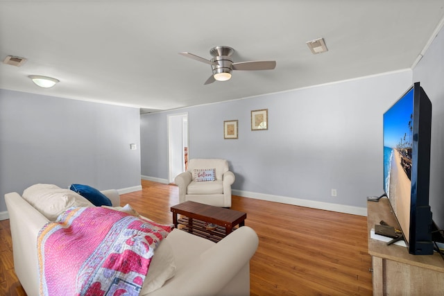 living room with hardwood / wood-style floors, ceiling fan, and ornamental molding