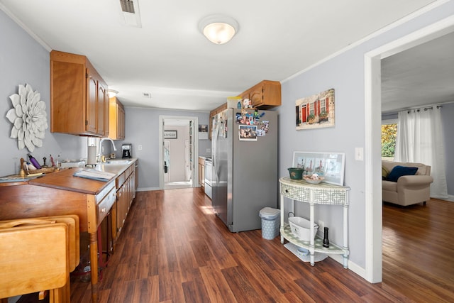 kitchen with electric stove, sink, crown molding, dark hardwood / wood-style flooring, and stainless steel refrigerator