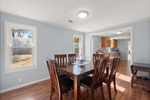 dining space featuring crown molding and dark hardwood / wood-style flooring