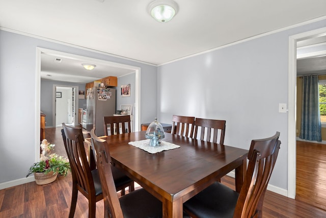 dining space featuring hardwood / wood-style flooring and crown molding