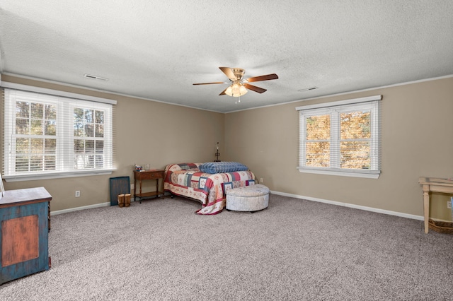 bedroom featuring multiple windows, a textured ceiling, carpet floors, and ceiling fan