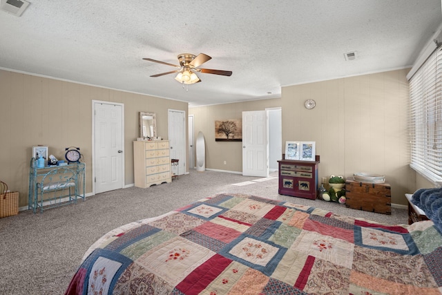 carpeted bedroom with a textured ceiling, ceiling fan, and crown molding