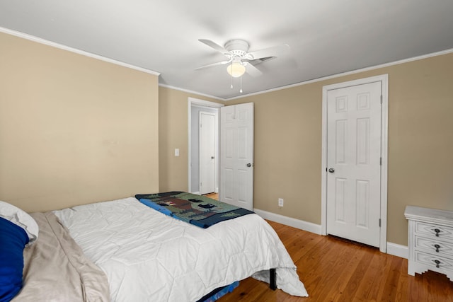 bedroom with hardwood / wood-style flooring, ceiling fan, and ornamental molding