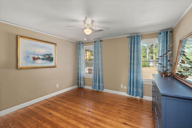 unfurnished room featuring ceiling fan, a healthy amount of sunlight, ornamental molding, and light hardwood / wood-style flooring