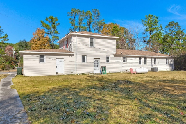 back of property with cooling unit and a lawn