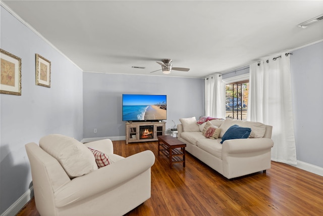 living room with ceiling fan, dark hardwood / wood-style flooring, and ornamental molding