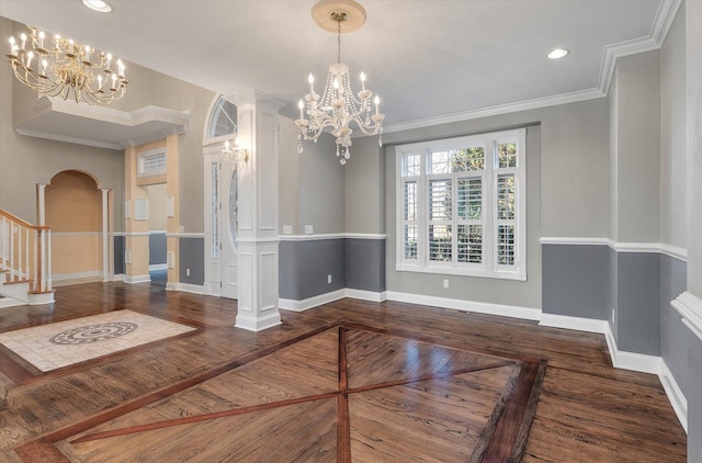 unfurnished dining area with crown molding, an inviting chandelier, and decorative columns