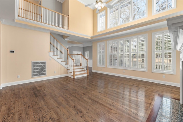 unfurnished living room with dark hardwood / wood-style floors, ceiling fan, and a high ceiling