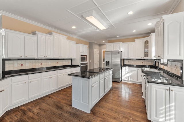 kitchen featuring stainless steel appliances, white cabinetry, and a center island