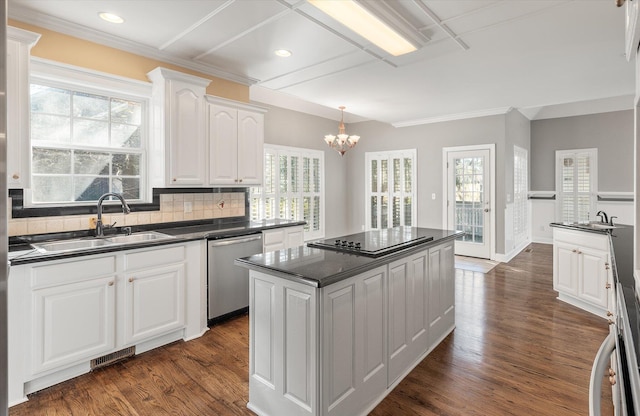 kitchen with a kitchen island, white cabinetry, sink, backsplash, and stainless steel dishwasher