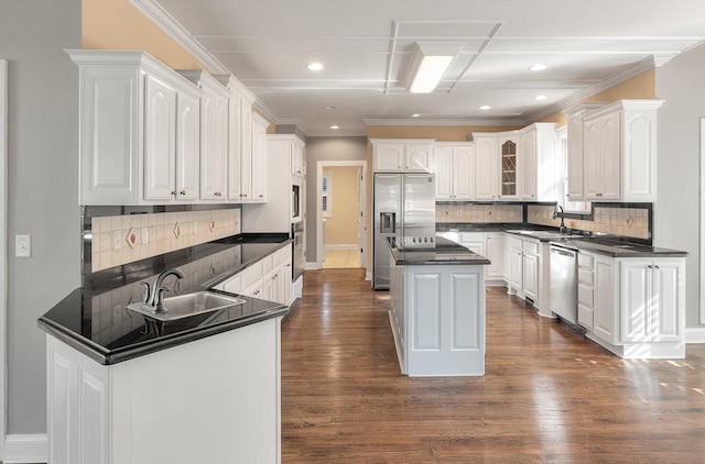 kitchen with tasteful backsplash, a kitchen island, white cabinets, and appliances with stainless steel finishes