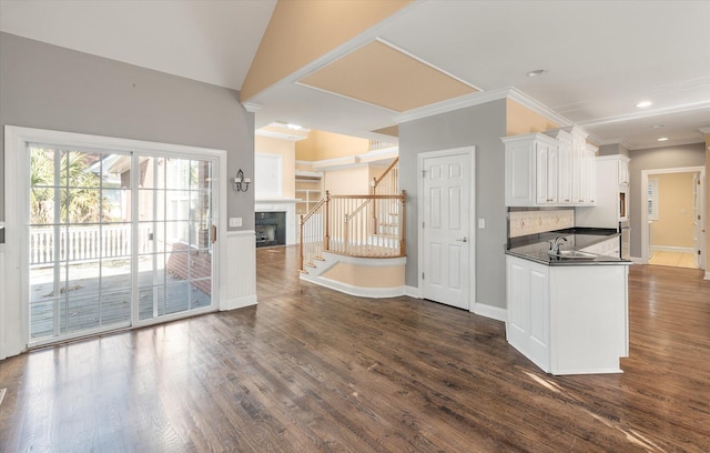 kitchen featuring sink, white cabinetry, backsplash, dark hardwood / wood-style floors, and vaulted ceiling