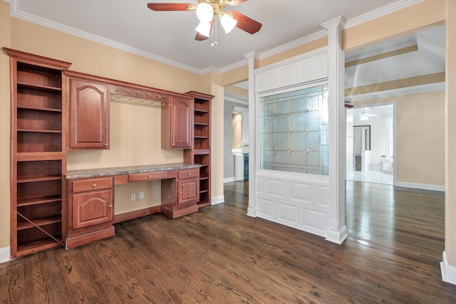 unfurnished office with crown molding, dark wood-type flooring, built in desk, and ceiling fan