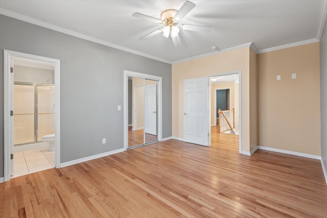 unfurnished bedroom featuring crown molding, ensuite bath, ceiling fan, a closet, and light wood-type flooring